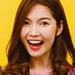 A woman with long brown hair smiling broadly against a yellow background. A woman with long brown hair smiling broadly against a yellow background.